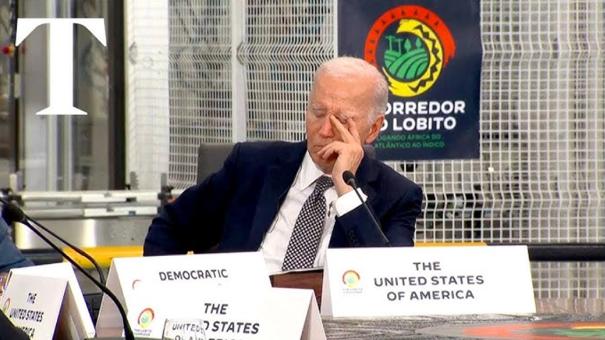 Biden appearing exhausted at a formal conference table
