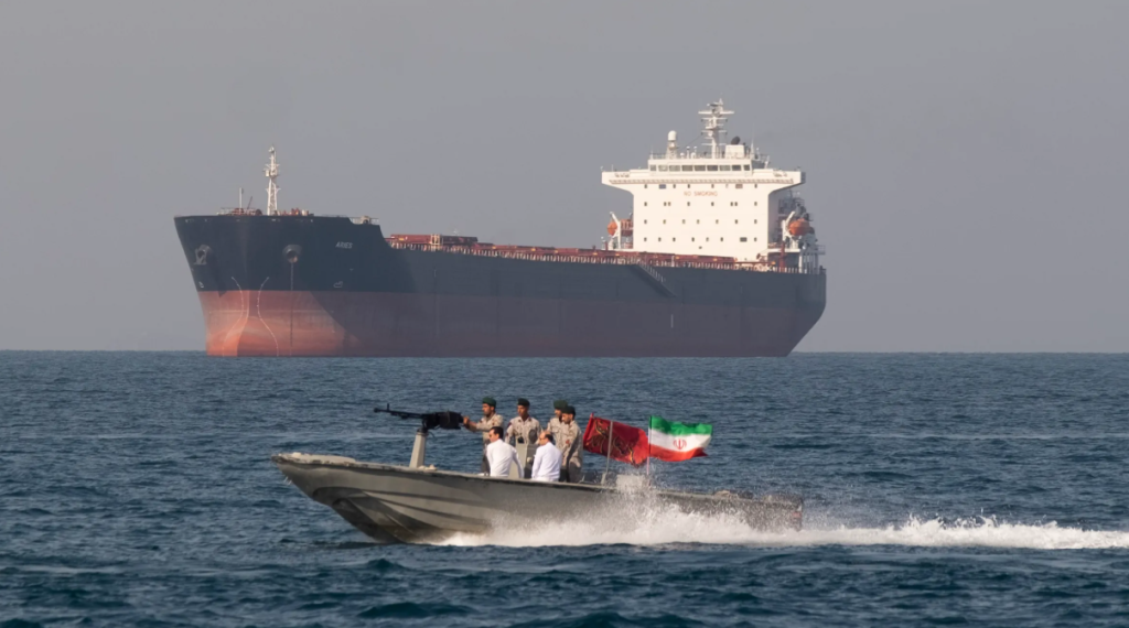 Iranian military speedboat patrolling near an oil tanker in the Strait of Hormuz