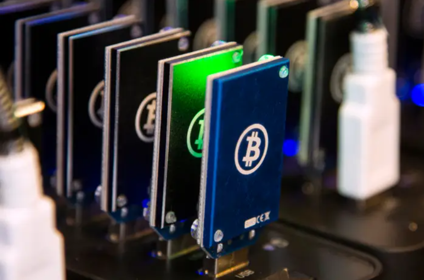 Close-up of Bitcoin ASIC mining devices with glowing logos