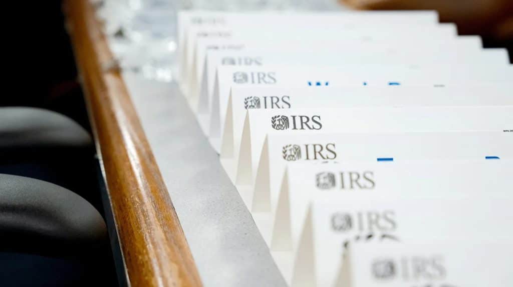 IRS envelopes stacked on a table, representing the paper-based IRS tax refund claim process under review