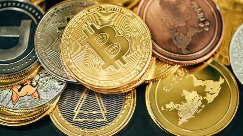 Multiple cryptocurrency coins illustrating crypto ETF inflows, Federal Reserve liquidity, and the crypto bull market.
