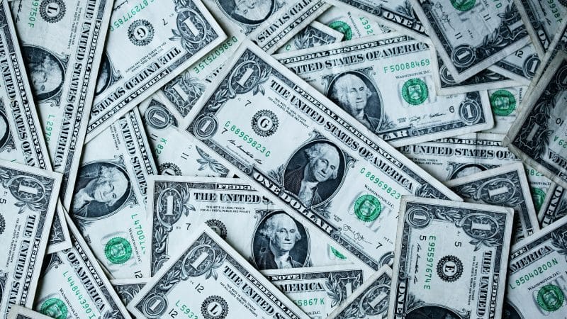 US dollar bills representing AI spending, AI spending per employee, corporate AI spending, AI adoption, and rising AI chips deman