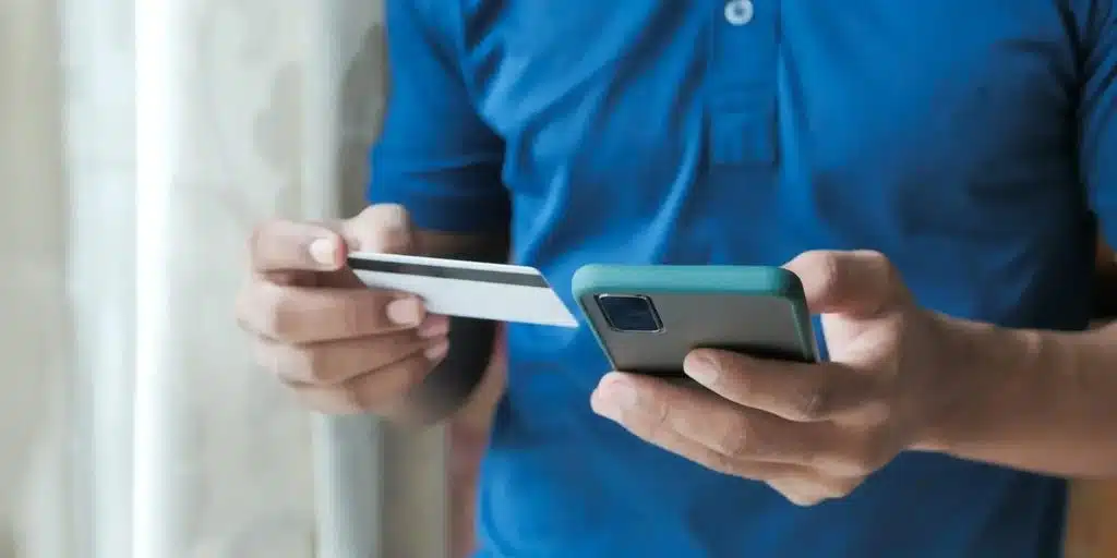 Person holding a phone and a card on his hand