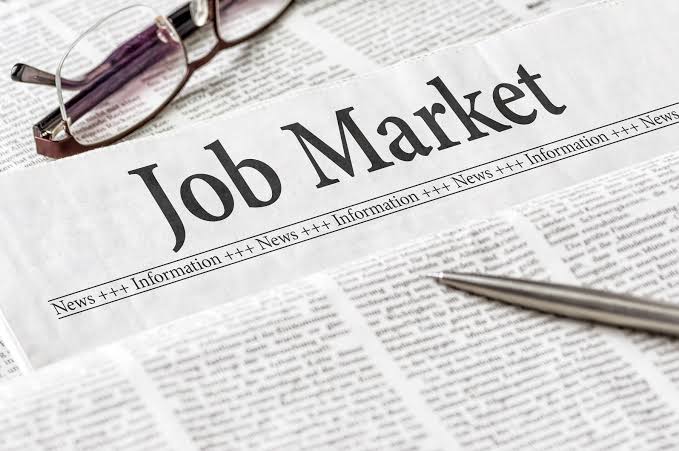 Job market newspaper image representing the US labor market, US jobs report, US financial jobs, US employment and US payroll revisions.